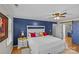 Comfortable main bedroom with blue accent wall, ceiling fan and natural light at 2016 Monaghan Ct, Matthews, NC 28105