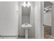 Clean powder room featuring pedestal sink and a modern mirror at 2019 Mcdonald Dr, Charlotte, NC 28216