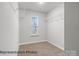Bright walk-in closet featuring carpeted floors, wire shelving, and a window providing natural light at 2019 Mcdonald Dr, Charlotte, NC 28216