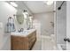 Bathroom featuring a wooden double vanity, stylish mirrors, tiled floors, and a walk-in shower at 232 Cromer St, Charlotte, NC 28208