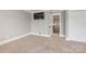 A bedroom featuring neutral carpet, light-gray walls, and a television with an open doorway at 232 Cromer St, Charlotte, NC 28208