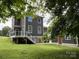Rear view of a well-maintained home featuring a deck and manicured lawn at 232 Cromer St, Charlotte, NC 28208