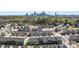 Aerial view of a townhome community with a cityscape backdrop, set among lush trees at 2446 Alyssa Ln, Charlotte, NC 28208