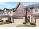Charming townhome featuring a red facade, brick accents, and a two-car garage at 2446 Alyssa Ln, Charlotte, NC 28208