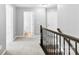 Bright hallway featuring neutral walls, carpet, and a dark wood railing, creating a modern and inviting space at 2446 Alyssa Ln, Charlotte, NC 28208