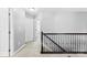 Well-lit hallway with neutral walls, carpet, dark wood railing and white doors, providing a clean and modern look at 2446 Alyssa Ln, Charlotte, NC 28208