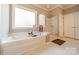 Bathroom featuring a bathtub, glass shower, and large window offering natural light at 2616 Creek Manor Dr, Waxhaw, NC 28173