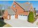 Angle view of brick home with a three car garage and long driveway at 2616 Creek Manor Dr, Waxhaw, NC 28173
