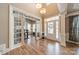 Bright foyer with hardwood floors, elegant lighting, and glass-paneled doors leading to other living spaces at 2616 Creek Manor Dr, Waxhaw, NC 28173