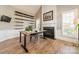 Well-lit home office with a fireplace, shelving, and hardwood floors, perfect for remote work at 2616 Creek Manor Dr, Waxhaw, NC 28173