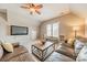 Spacious living room features a comfortable leather sofa, ceiling fan, and a window with bench seating at 2616 Creek Manor Dr, Waxhaw, NC 28173