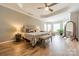 This is a spacious main bedroom with a sitting area, ceiling fan, and wood laminate flooring at 2616 Creek Manor Dr, Waxhaw, NC 28173