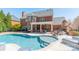A gorgeous in-ground pool features a tanning ledge, stone surround, and covered patio at 2616 Creek Manor Dr, Waxhaw, NC 28173