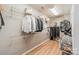 Walk-in closet with shelving, wood flooring, and clothing racks providing storage solutions at 2616 Creek Manor Dr, Waxhaw, NC 28173