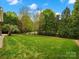 Well-manicured backyard featuring lush greenery and fencing, creating a serene and private outdoor space at 3100 Stanway Ct, Waxhaw, NC 28173