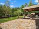 Large backyard featuring a covered patio, outdoor kitchen, and a stone patio, perfect for outdoor gatherings and relaxation at 3100 Stanway Ct, Waxhaw, NC 28173