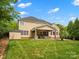 Lush backyard featuring a covered patio, manicured lawn, and mature trees, providing a private and tranquil outdoor retreat at 3100 Stanway Ct, Waxhaw, NC 28173