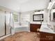 Bright bathroom with a double vanity, soaking tub, glass-enclosed shower, and tile floor at 3100 Stanway Ct, Waxhaw, NC 28173