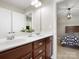 Bathroom featuring dual sinks, wood cabinets, and access to bedroom at 3100 Stanway Ct, Waxhaw, NC 28173