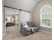 Bedroom featuring a sliding barn door leading to an upholstered chair and natural light at 3100 Stanway Ct, Waxhaw, NC 28173
