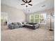 Bonus room features a large window, plush carpet, and comfortable sectional sofa at 3100 Stanway Ct, Waxhaw, NC 28173