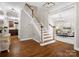 Open foyer featuring hardwood floors, staircase, and an entry to the living room at 3100 Stanway Ct, Waxhaw, NC 28173