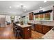 Open kitchen with granite countertops, wooden cabinetry, a central island, and easy access to living spaces at 3100 Stanway Ct, Waxhaw, NC 28173