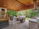 Outdoor covered patio with lounge furniture, built-in grilling area, and wood ceiling at 3100 Stanway Ct, Waxhaw, NC 28173