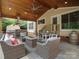 Covered patio featuring wood ceiling, outdoor kitchen, seating and dining areas, offering a serene outdoor living space at 3100 Stanway Ct, Waxhaw, NC 28173