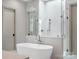 Luxurious bathroom with a freestanding tub, glass-enclosed shower, and marble countertops at 3212 Willow Oak Rd, Charlotte, NC 28209