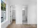 Bright hallway view with hardwood floors, white trim and access to storage and bathroom areas at 3212 Willow Oak Rd, Charlotte, NC 28209