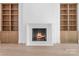 Cozy living room featuring built-in bookshelves and fireplace with hearth at 3212 Willow Oak Rd, Charlotte, NC 28209