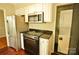 Efficient kitchen with stainless steel appliances, white cabinets, and convenient access to laundry area at 3238 Pinehurst Pl # B, Charlotte, NC 28209