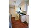 Galley kitchen with dark countertops, stainless steel appliances, and hardwood floors offers efficient meal prep space at 3238 Pinehurst Pl # B, Charlotte, NC 28209