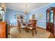 Formal dining room with hardwood floors, blue walls, china cabinet, chandelier, and large dining table at 3412 Country Club Dr, Gastonia, NC 28056