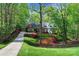 Scenic view of brick home nestled among lush greenery, highlighting landscaping and driveway at 3412 Country Club Dr, Gastonia, NC 28056