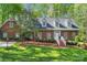 Charming brick home with manicured lawn, dormer windows, and inviting front entrance with white stairs at 3412 Country Club Dr, Gastonia, NC 28056