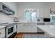Charming kitchen boasting white cabinetry, subway tile, stainless appliances, and hardwood floors at 3412 Country Club Dr, Gastonia, NC 28056