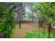 View of the backyard framed by an arbor with lush greenery, a wooden fence and the home in the background at 3726 Providence Rd, Charlotte, NC 28211