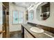 Modern bathroom featuring a single sink vanity with storage, complemented by decorative mirrors and tile work at 3726 Providence Rd, Charlotte, NC 28211