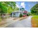 Charming home with lush landscaping and a long driveway under a bright, partly cloudy sky at 3726 Providence Rd, Charlotte, NC 28211