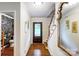 Inviting foyer features hardwood floors, a wooden staircase, and access to a floral-themed powder room at 3726 Providence Rd, Charlotte, NC 28211