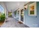 Cozy front porch with tiled floor, white pillars and railings, and a ceiling fan for outdoor comfort at 3726 Providence Rd, Charlotte, NC 28211