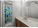 Bathroom with printed blue shower curtain, sink with white countertop and wooden cabinets at 3908 Parkers Ferry Rd, Fort Mill, SC 29715