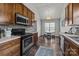 Well-lit kitchen with wooden cabinets, black appliances, an eating area and hardwood floors at 3908 Parkers Ferry Rd, Fort Mill, SC 29715