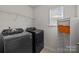 Laundry room with washer, dryer, metal shelves, and cabinet with an orange bin at 3908 Parkers Ferry Rd, Fort Mill, SC 29715