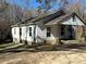 Exterior view of a single-story home with a covered porch and mature trees in a natural setting at 406 E Earnhardt St, Salisbury, NC 28144