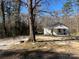Distant exterior shot of a quaint single-story house surrounded by mature trees at 406 E Earnhardt St, Salisbury, NC 28144
