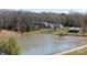 Scenic aerial view featuring a serene lake, a dock, surrounding trees, and well-maintained grassy areas at 4229 Motocross Trl, Edgemoor, SC 29712