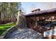 Rustic building featuring a stone chimney, wood siding, and an inviting outdoor patio at 4229 Motocross Trl, Edgemoor, SC 29712